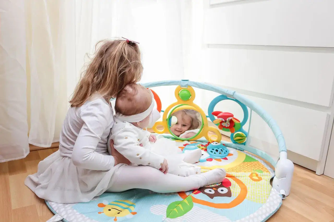 rodzic bawi się z dzieckiem na macie edukacyjnej