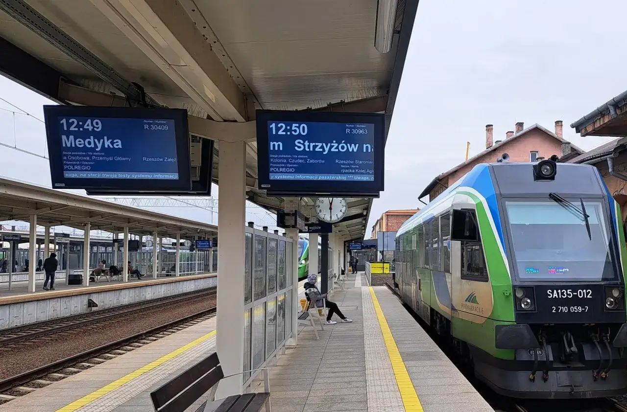 Na dworcu w Rzeszowie wyświetlane są informacje o odjazdach pociągów. Rozkład jazdy PKP Rzeszów pokazuje pociąg do Medyki o 12:49 i do Strzyżowa o 12:50.