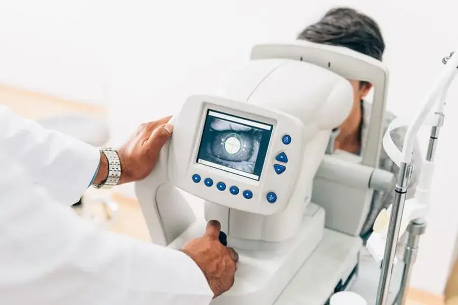 Technik okulista przy pracy sprzęt diagnostyczny