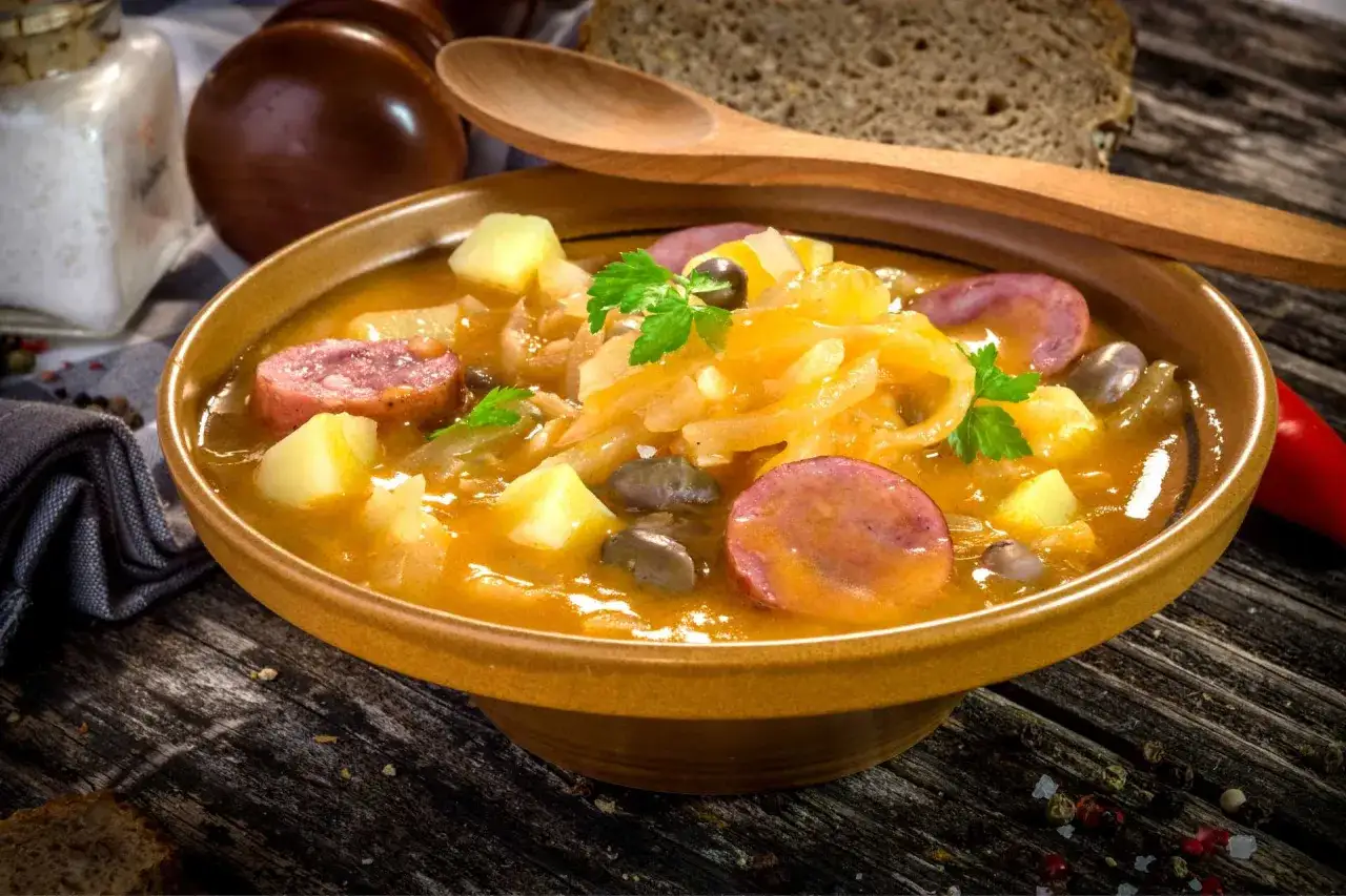 Gęsta zupa z kapusty kiszonej, ziemniak&oacute;w i kiełbasy, serwowana w glinianej misce. Prawdziwy smak kuchni słoweńskiej.