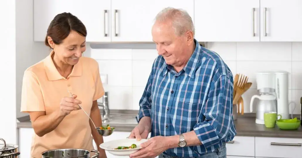 opiekunka pomaga seniorowi w domu