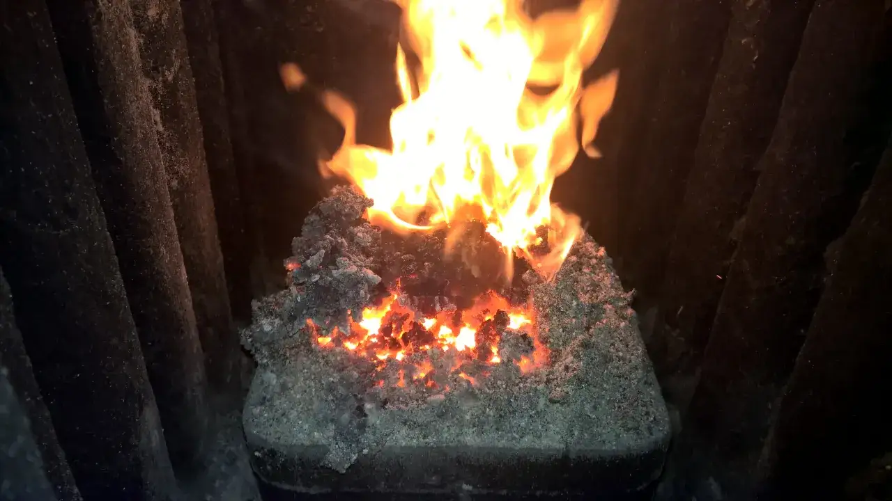 Żarzące się węgle i płomienie w piecu, pokazujące, jak palić miał w zwykłym piecu.