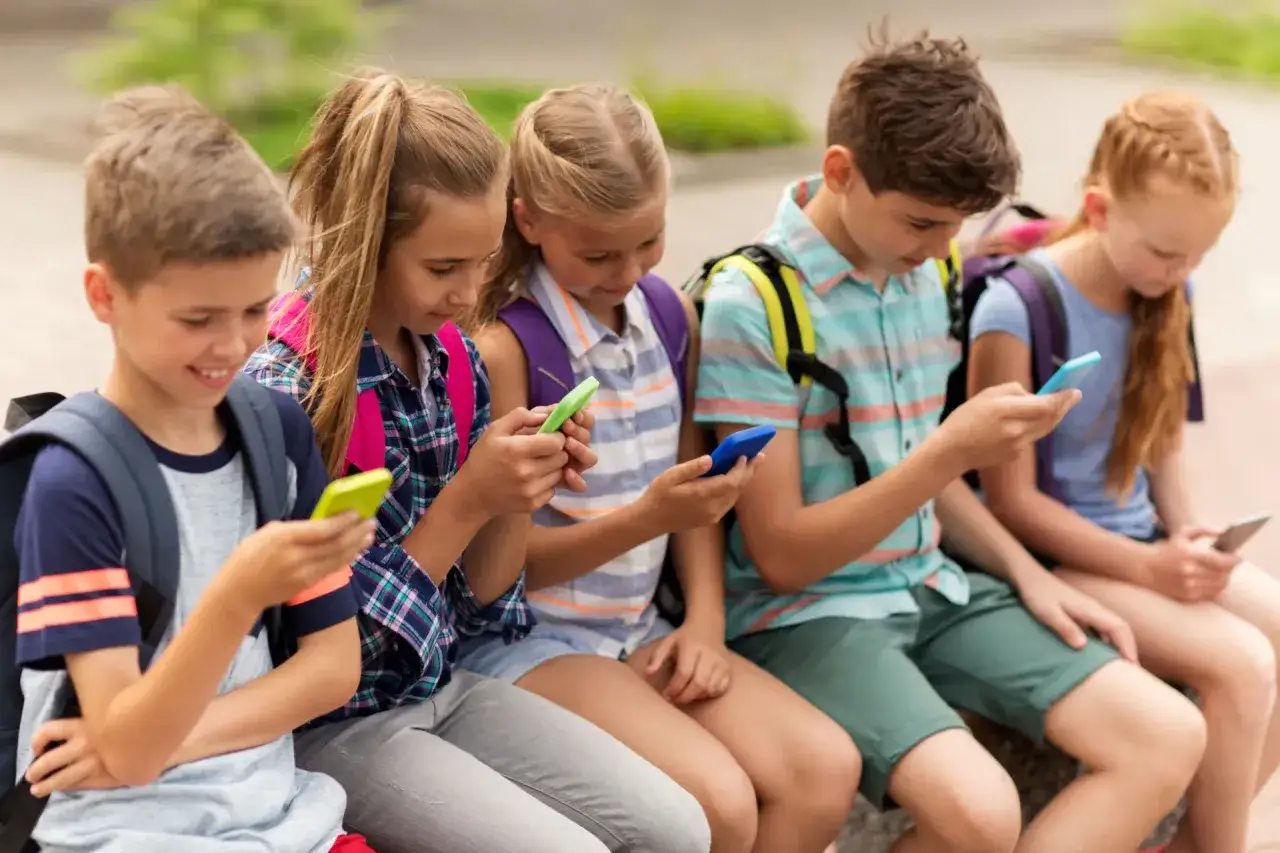 dziecko używające smartfona na zewnątrz