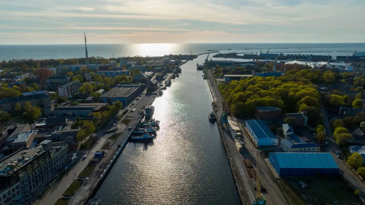 Widok na port i kanał, który prowadzi do morza. To dowód, że Łotwa ma dostęp do morza, z widocznymi statkami i przemysłem.