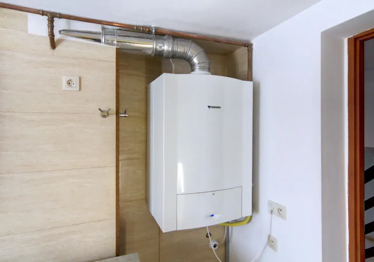 Nowoczesny piec gazowy 25 kW, idealny do ogrzania średniej wielkości domu lub mieszkania. Zamontowany na ścianie, podłączony do instalacji.
