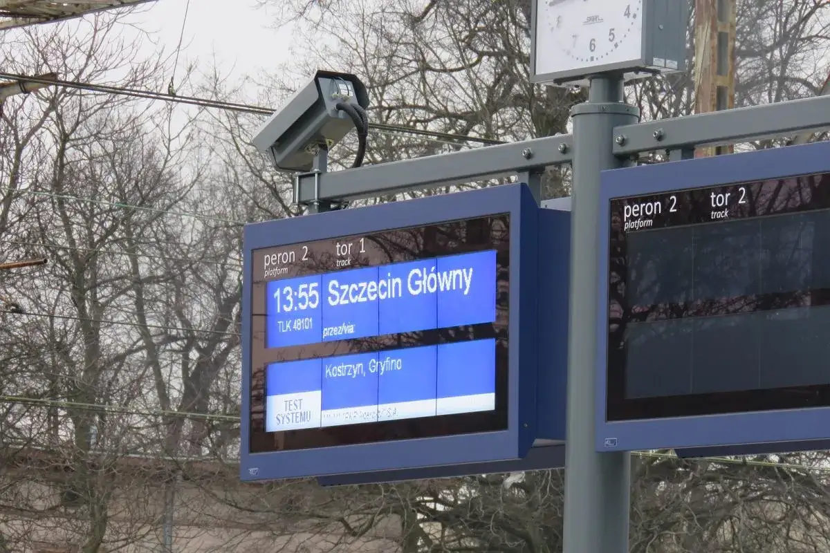 elektroniczna tablica odjazd&oacute;w pociąg&oacute;w na dworcu