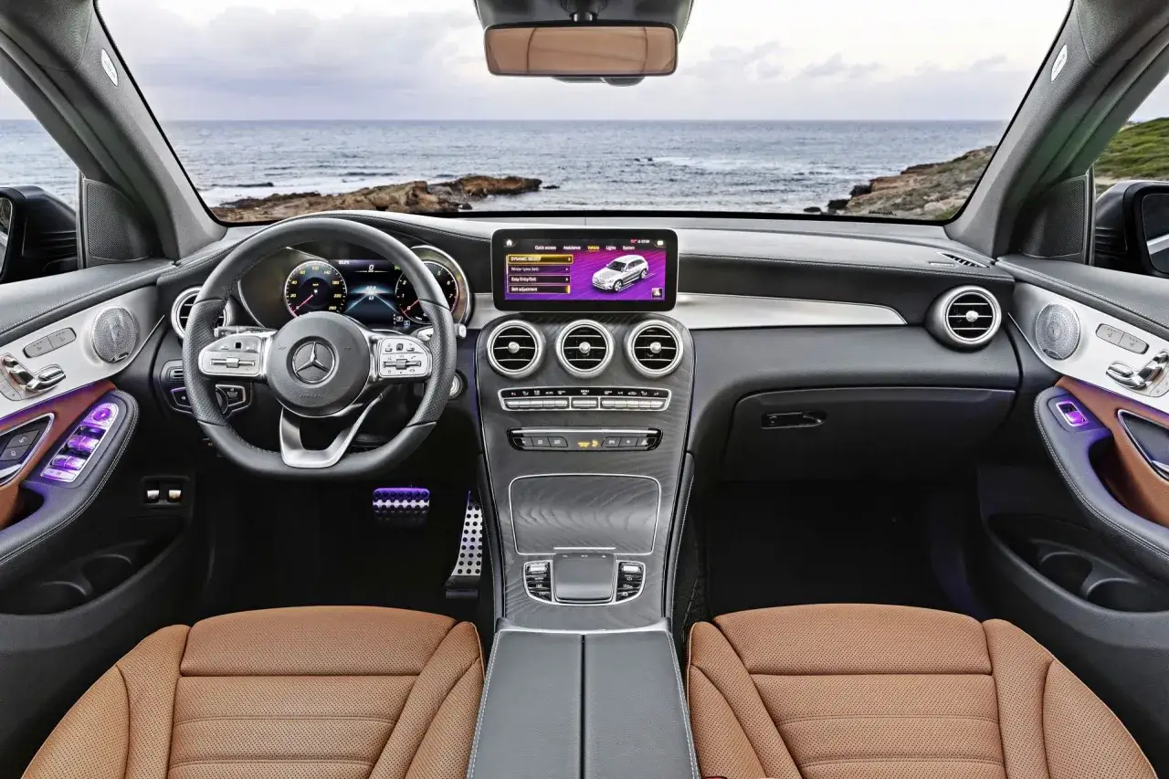 Wnętrze Mercedesa GLC 300 4MATIC z brązową skórzaną tapicerką i widokiem na morze.