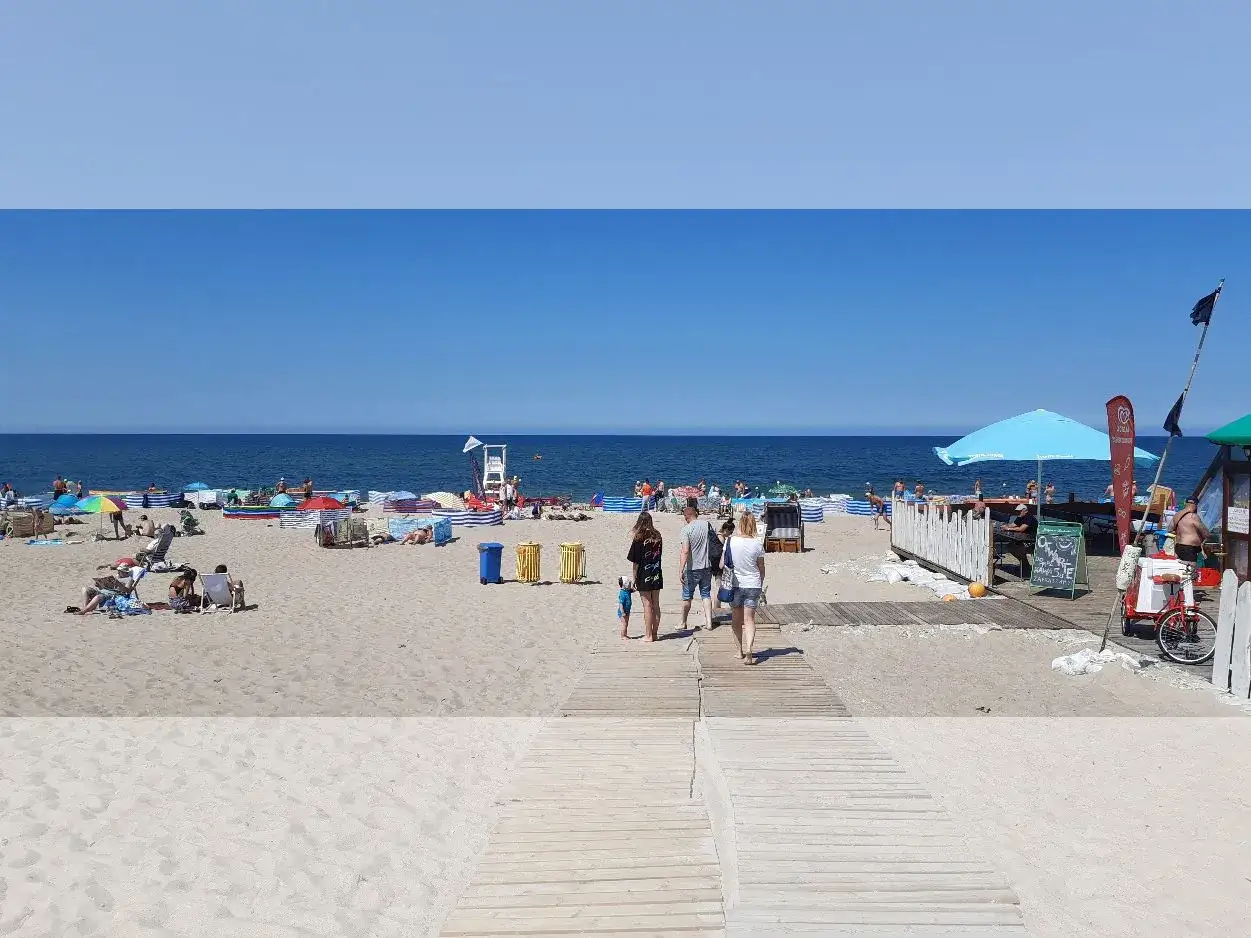 Słoneczna plaża z turystami, idealna na wakacje w najlepszych hotelach nad morzem z pełnym wyżywieniem.