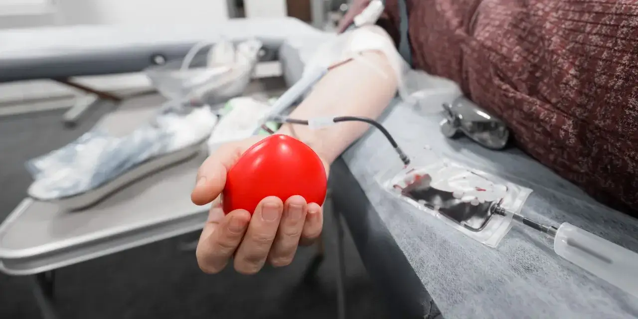 Osoba pijąca wodę po oddaniu krwi