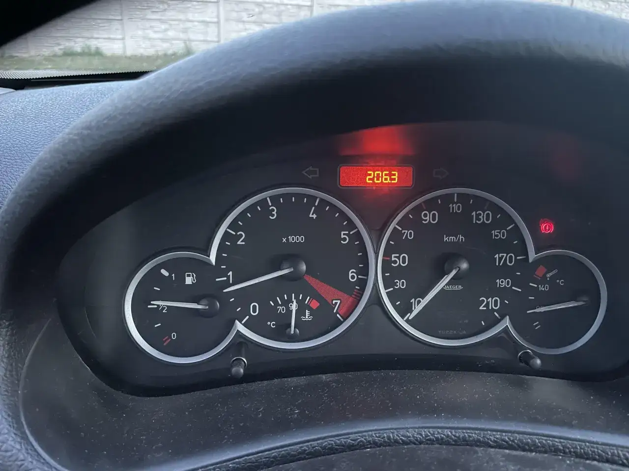 Deska rozdzielcza Peugeot 206 1.4 HDI. Cyfrowy wskaźnik pokazuje 206.3, a obok wskaźnik paliwa.