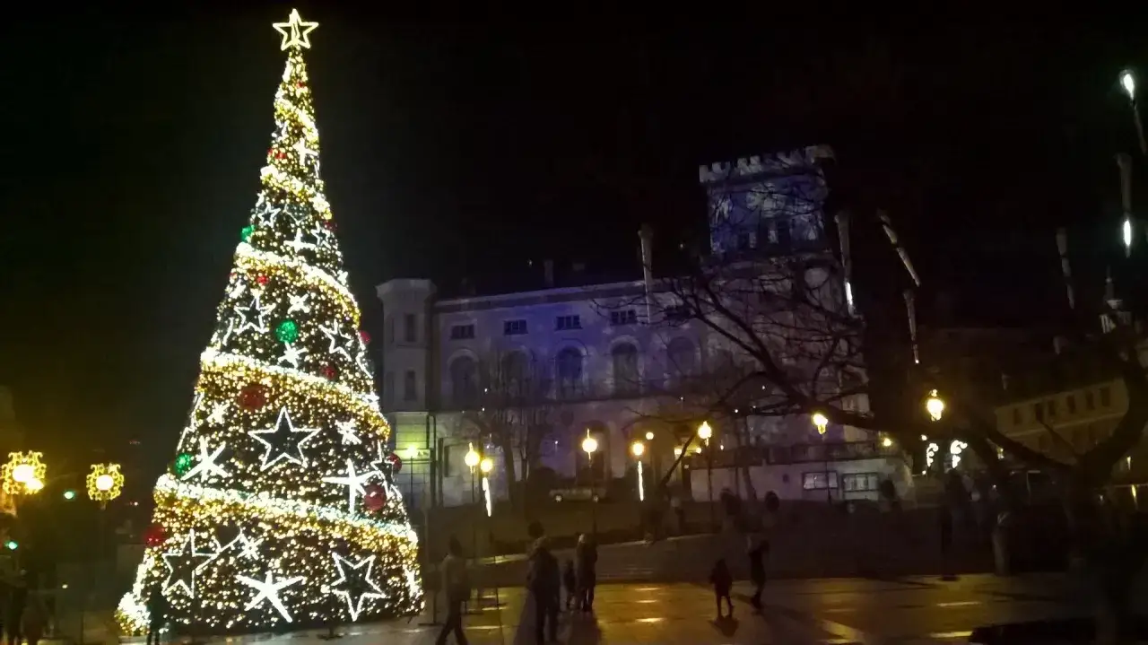 Oświetlona choinka i budynek w tle. Idealne miejsce, gdzie pojechać na święta bożego narodzenia w polsce.
