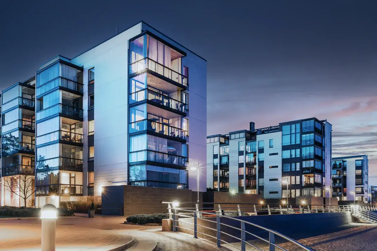 Nowoczesne apartamentowce z przeszklonymi balkonami, idealne na umowę kupna sprzedaży mieszkania.