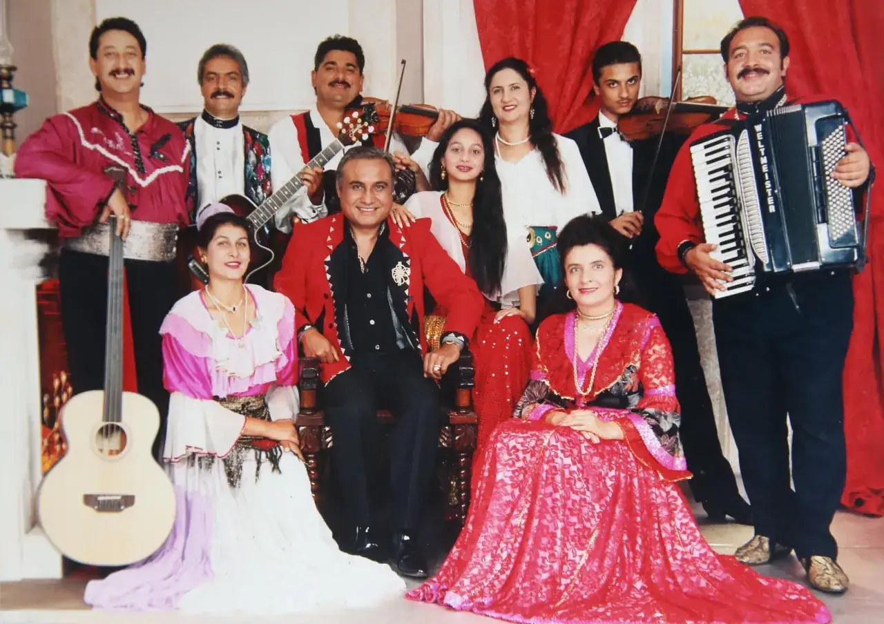 Agnieszka, córka Don Vasyla, w otoczeniu rodziny i muzyków, pozuje do zdjęcia w barwnych strojach.