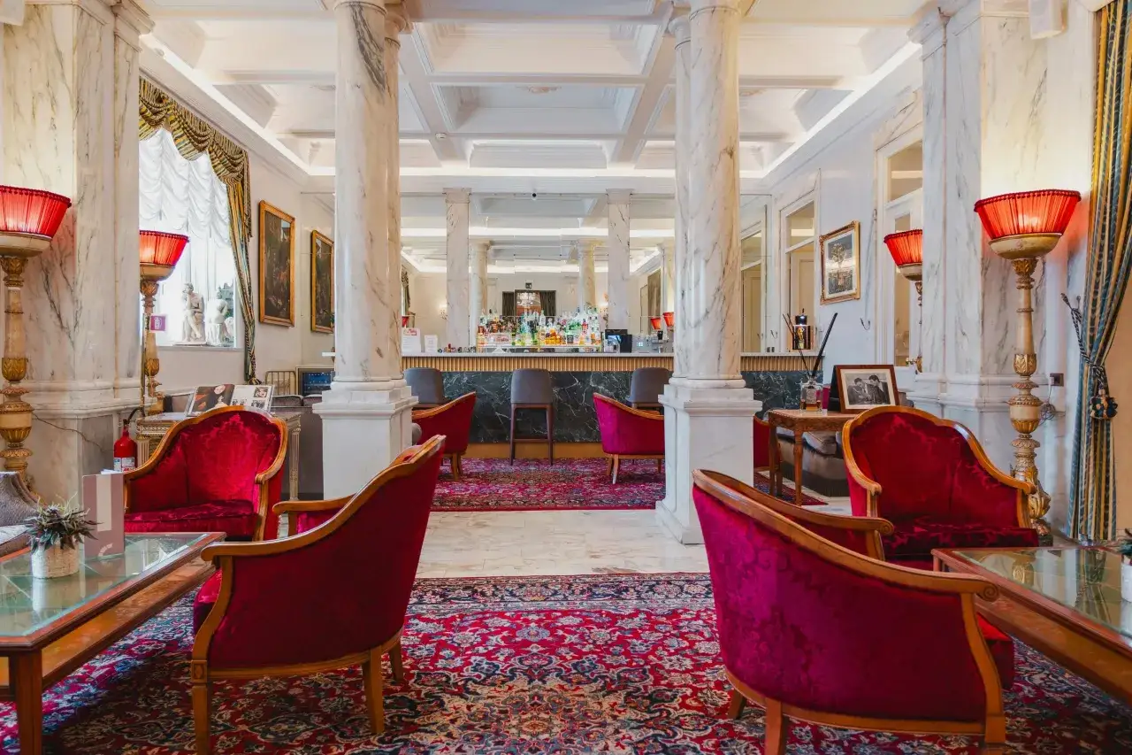 Eleganckie fotele i bar w hotelu, gdzie można sprawdzić, ile kosztuje nocleg w Rzymie.