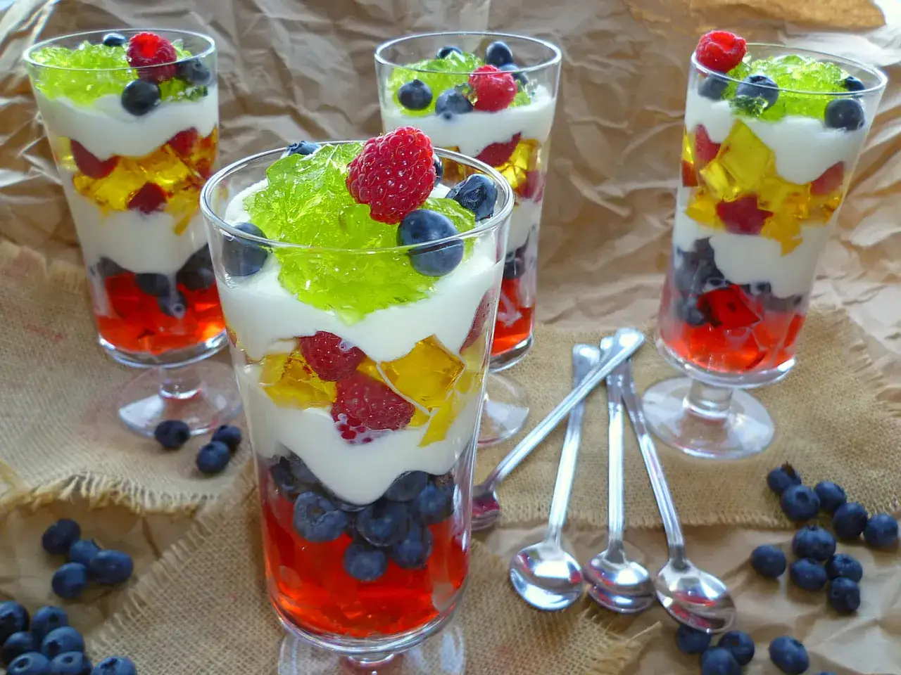 Kolorowy deser z galaretki z owocami i bitą śmietaną. Idealny przepis na letnie orzeźwienie.