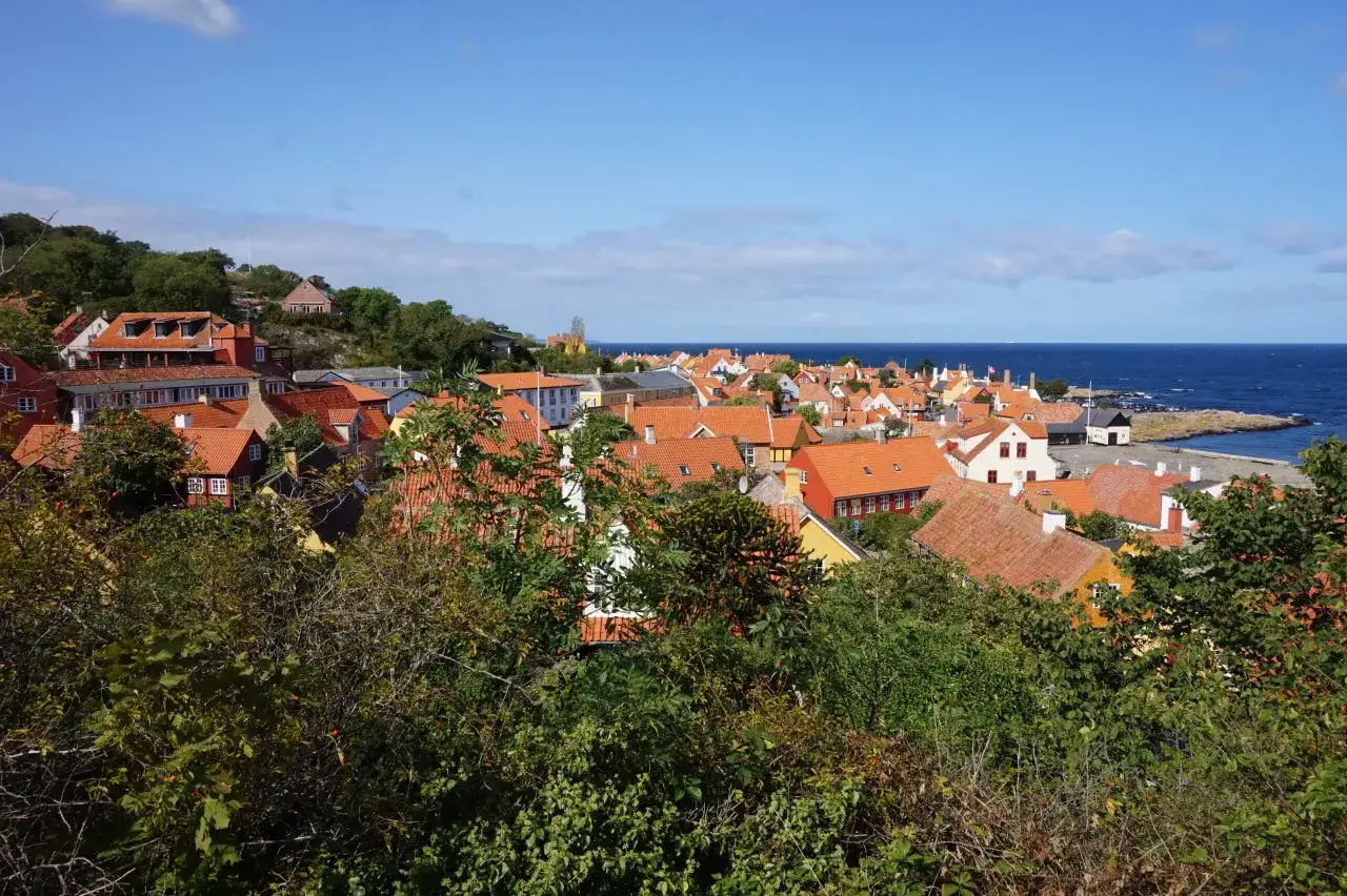 Urokliwa panorama Bornholmu z czerwonymi dachami i morzem. Warto zobaczyć to malownicze miasteczko!