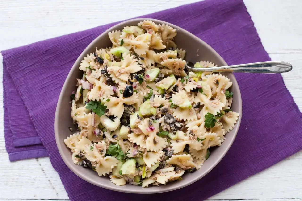 Pyszna sałatka z tuńczykiem i makaronem farfalle, z dodatkiem og&oacute;rka, oliwek i cebuli. Idealna na szybki lunch.