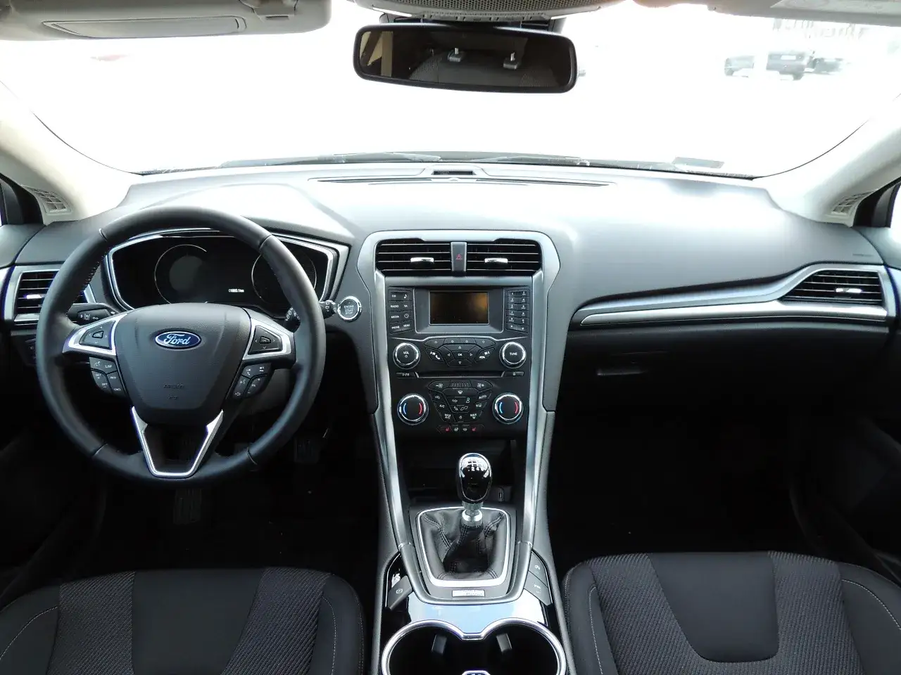 Wnętrze Ford Mondeo MK5: kierownica, deska rozdzielcza z ekranem multimediów i dźwignia zmiany biegów.