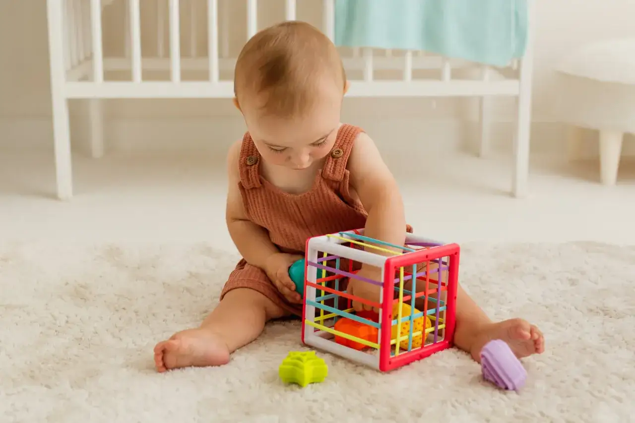 dziecko bawi się elastyczną kostką sensoryczną