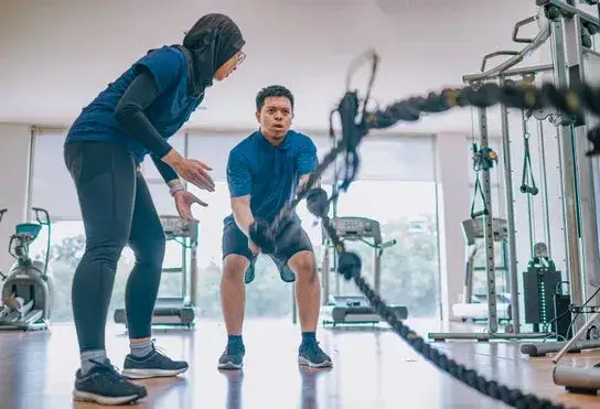 Entrenador personal con cliente en gimnasio Santander