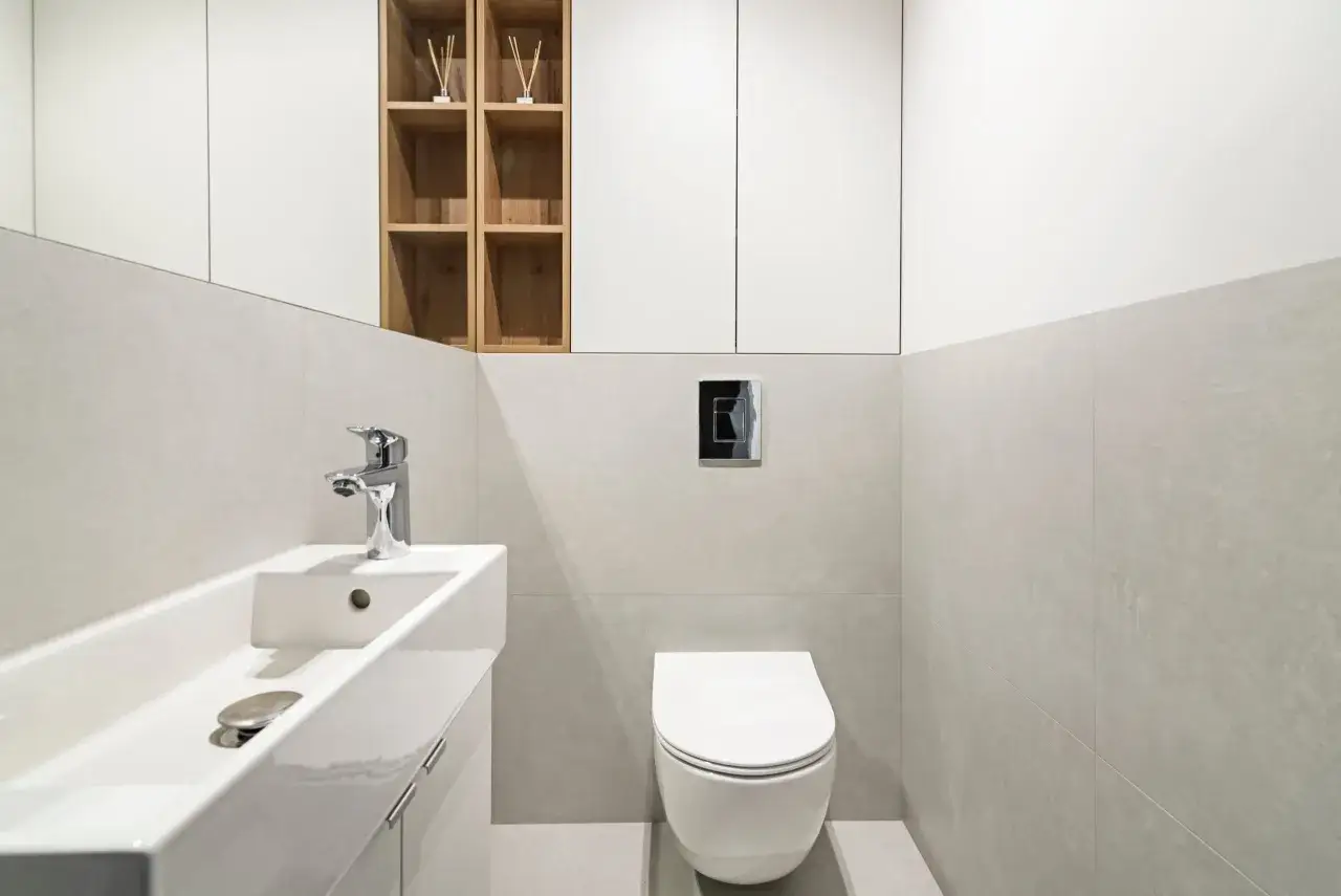 Nowoczesna łazienka z umywalką i podwieszaną miską WC. Widoczny przycisk spłukujący Geberit. Mam nadzieję, że geberit cieknie woda, bo inaczej to tylko dekoracja.