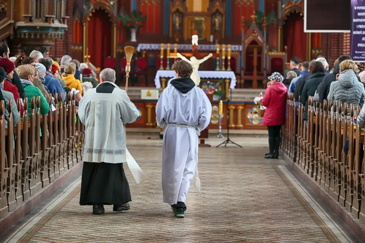 W kościele trwa msza. Wierni siedzą w ławkach, a ksiądz z ministrantem idzie do ołtarza. Ile trwa msza w niedzielę wielkanocną?