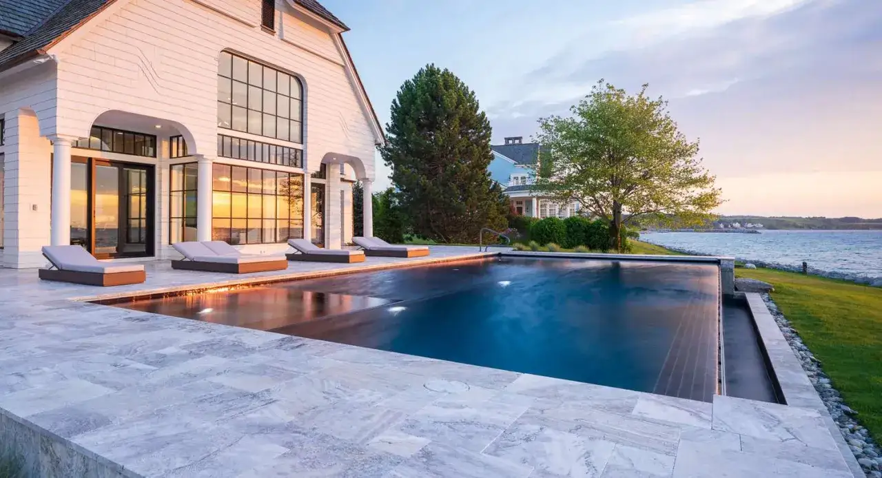 Nowoczesny basen w ogrodzie, z leżakami i widokiem na morze. Inspiracje dla Twojego wymarzonego miejsca relaksu.