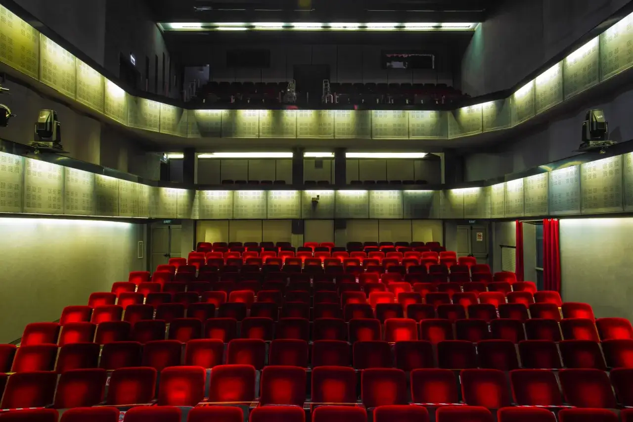 Puste czerwone fotele w teatrze Bagatela, widok na lożę i balkon.