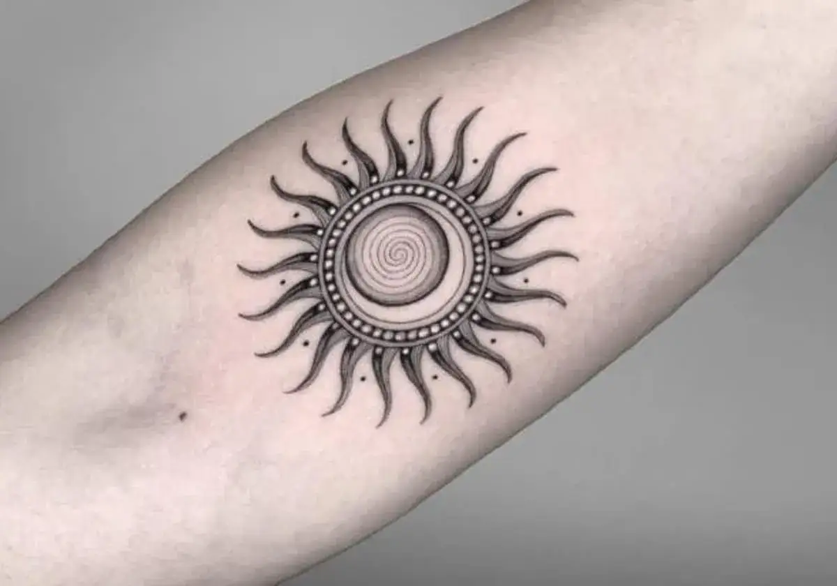 Tatuaż symbol słońca znaczenie: spiralny dysk otoczony promieniami, symbolizujący energię i odrodzenie.