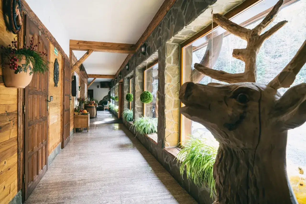 Drewniana rzeźba białego jelenia wita gości w korytarzu bac&oacute;wki.