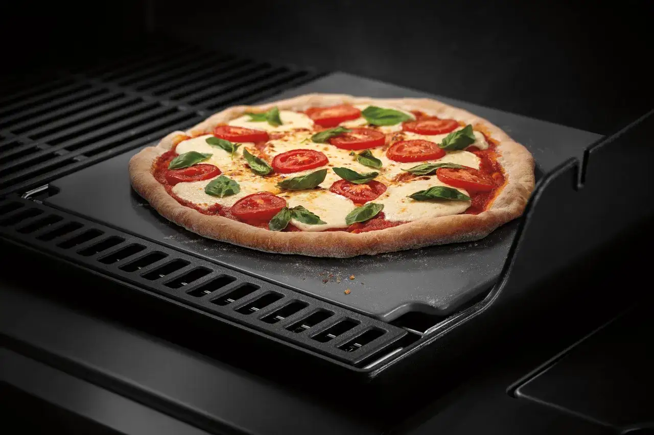Margherita pizza na kamieniu grillowym. Dowiedz się, jak przełożyć pizzę na kamień bez łopatki, by uzyskać idealnie wypieczony sp&oacute;d.