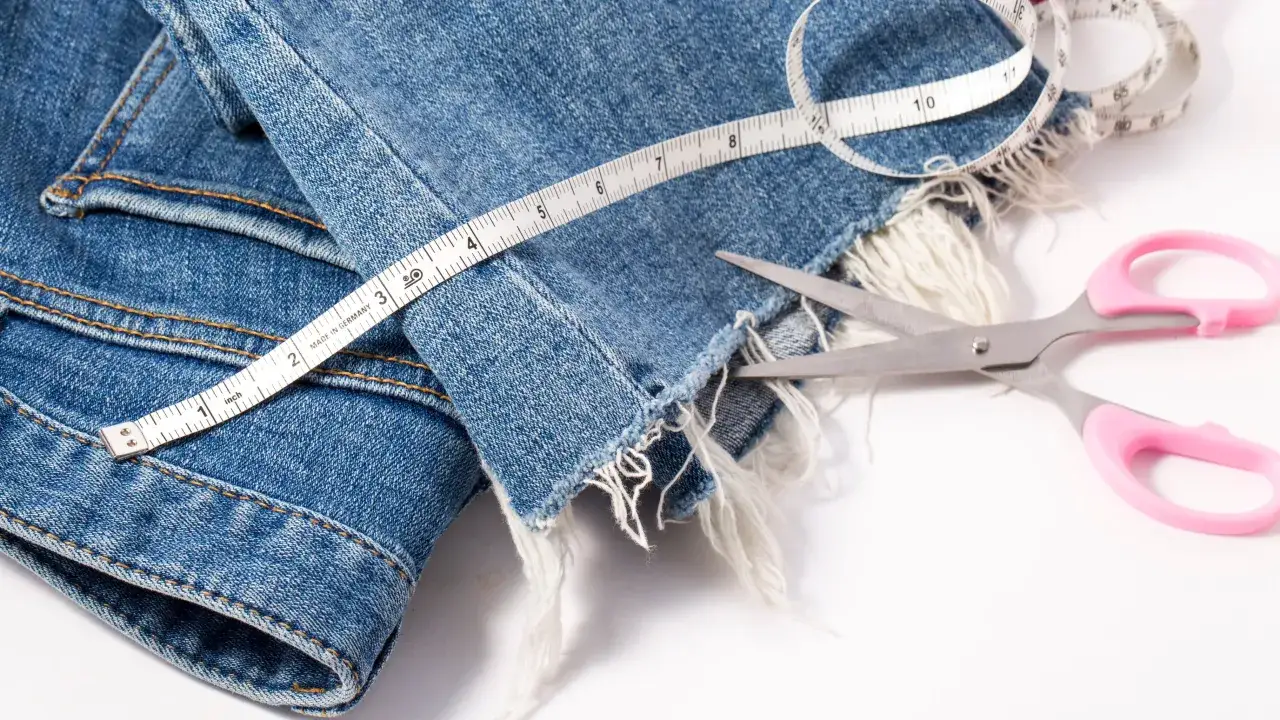 Osoba mierząca długość spodni przed lustrem