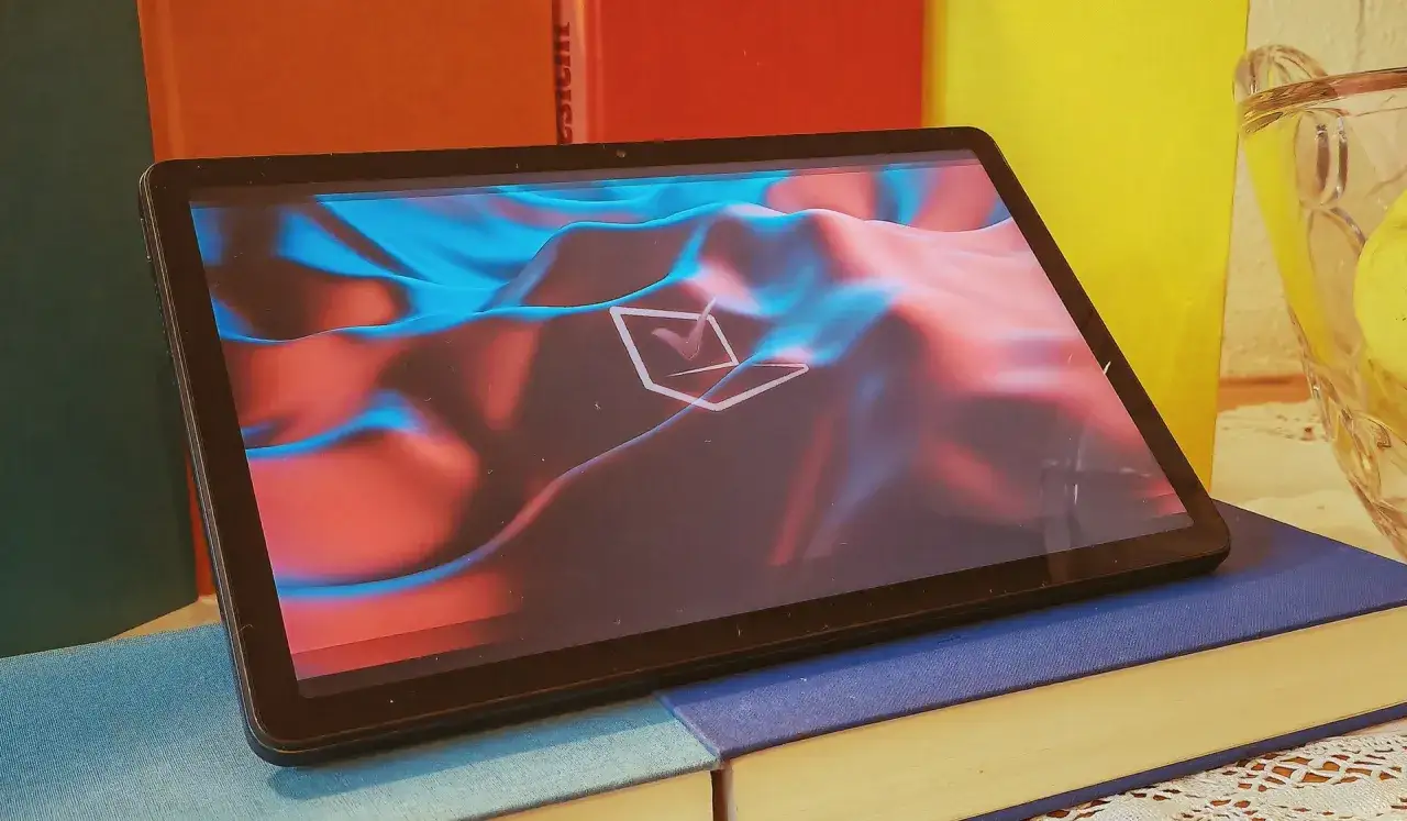 Tablet z abstrakcyjnym tłem, przypominającym g&oacute;ry w odcieniach czerwieni i błękitu. Czy to nowy cellular?