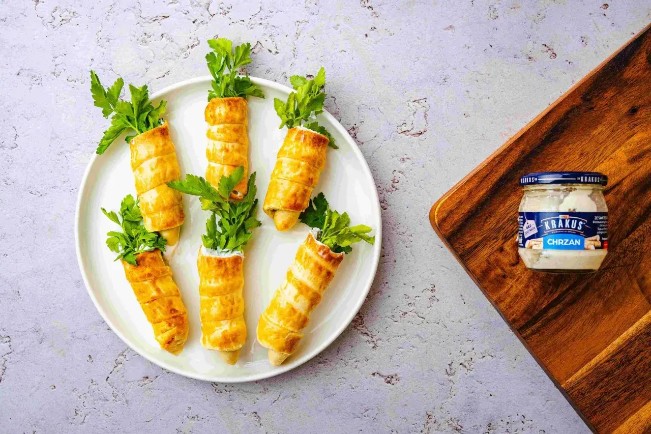 Wielkanocne przystawki w kształcie marchewek, zawinięte w ciasto francuskie, z natką pietruszki i chrzanem Krakus.