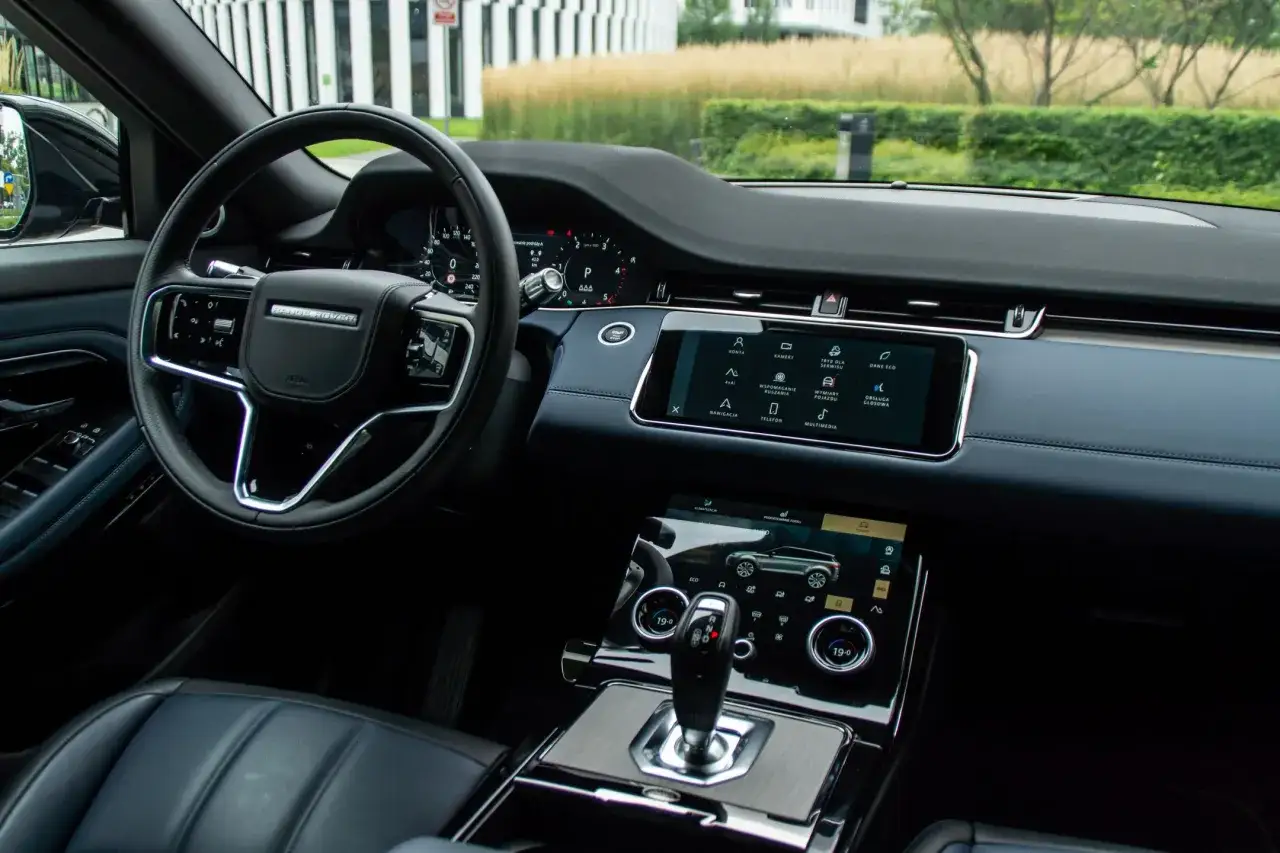 Wnętrze Land Rover Evoque: kierownica, deska rozdzielcza z ekranem dotykowym i panelem klimatyzacji.
