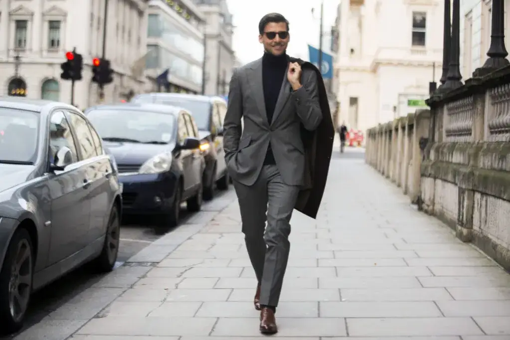 Mężczyzna w czarnej koszuli i szarych spodniach chinos