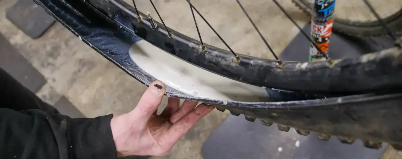Dłoń pokazuje wnętrze obręczy rowerowej z płynem uszczelniającym, gotowym do montażu opon tubeless.