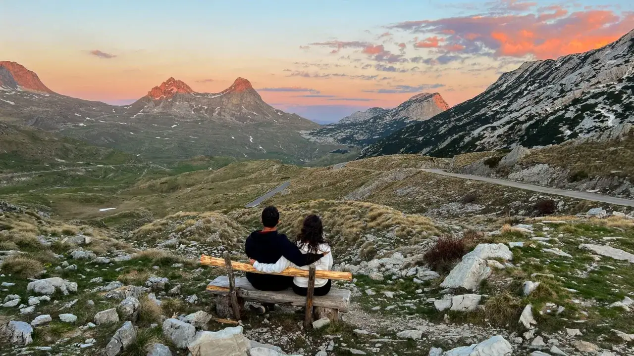Para zakochanych podziwia zach&oacute;d słońca w g&oacute;rach Czarnog&oacute;ry. Niesamowite czarnog&oacute;ra widoki zapierają dech w piersiach.