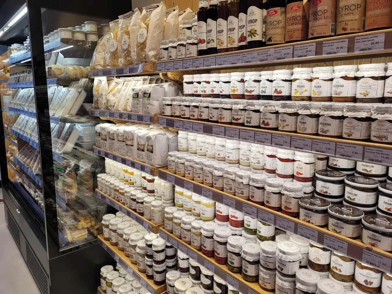 Bac&oacute;wka towary tradycyjne Krak&oacute;w: p&oacute;łki uginają się od słoik&oacute;w z dżemami, syropami i przetworami.