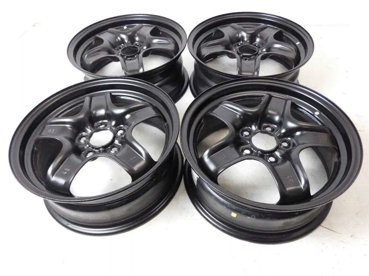 Cztery stalowe felgi do Astry H, z pięcioma otworami na śruby. Rozstaw śrub jest kluczowy dla dopasowania.