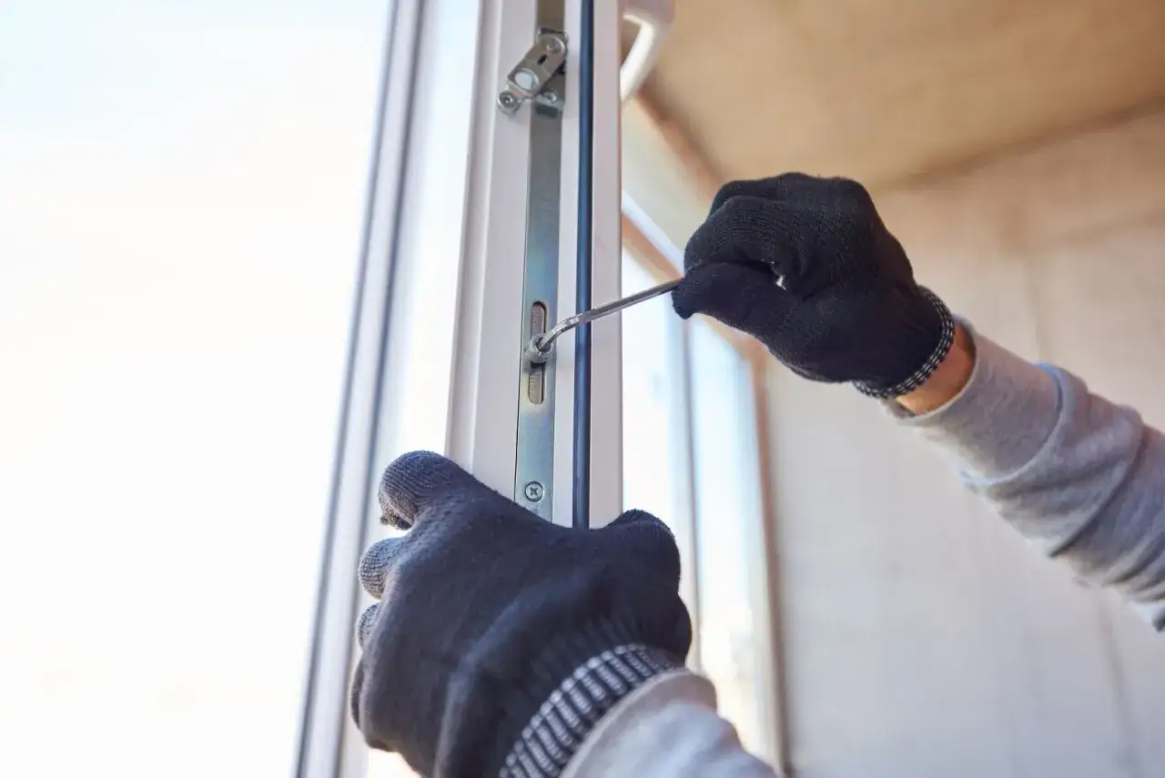 Ręce w rękawiczkach regulują mechanizm okna, przygotowując je do trybu zimowego.