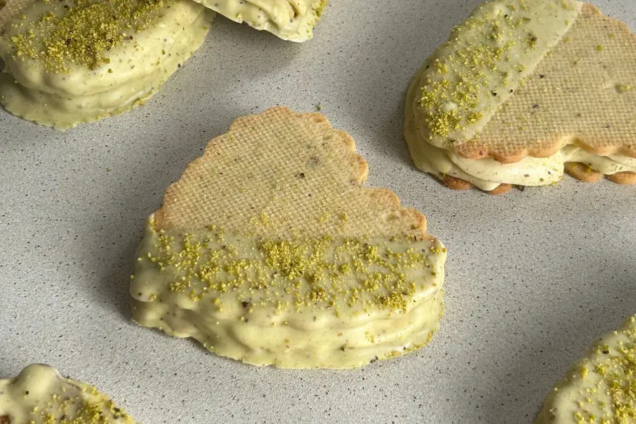 Pyszne ciastka z kremem pistacjowym, zanurzone w pistacjowej polewie i posypane kruszonymi pistacjami.