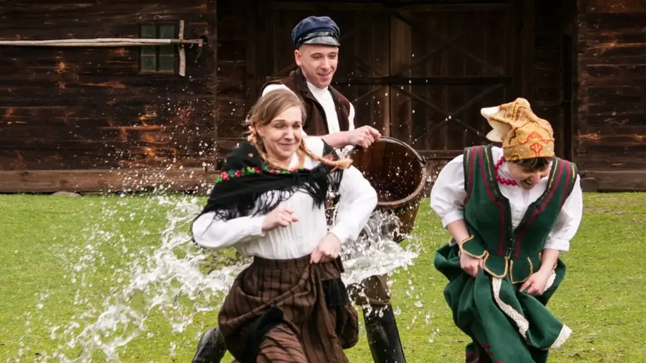 Radosny śmigus dyngus z życzeniami! Ludzie w strojach ludowych biegają, a woda tryska wokół.