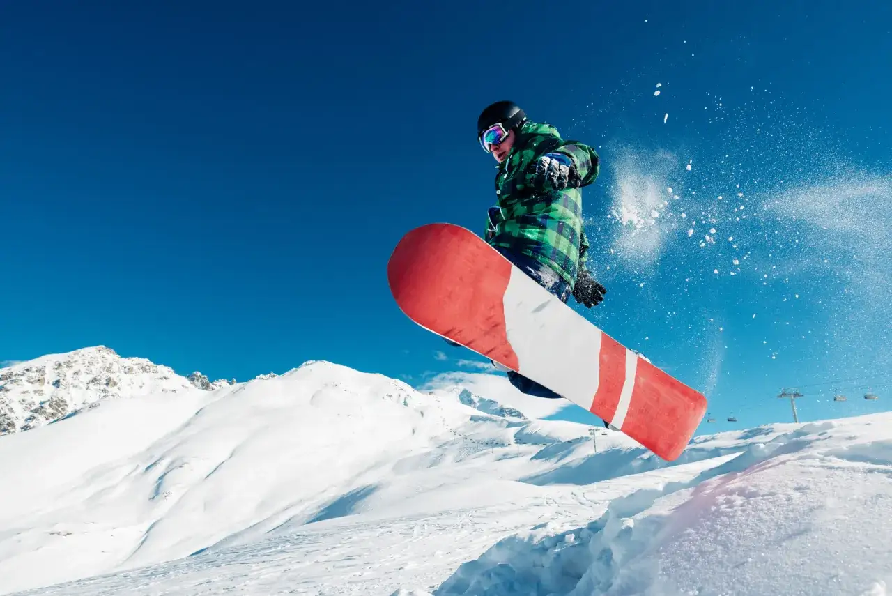 Snowboardzista w skoku, jakby odzwierciedlał ducha wolności, który narodził się wraz z rozwojem snowboardu.