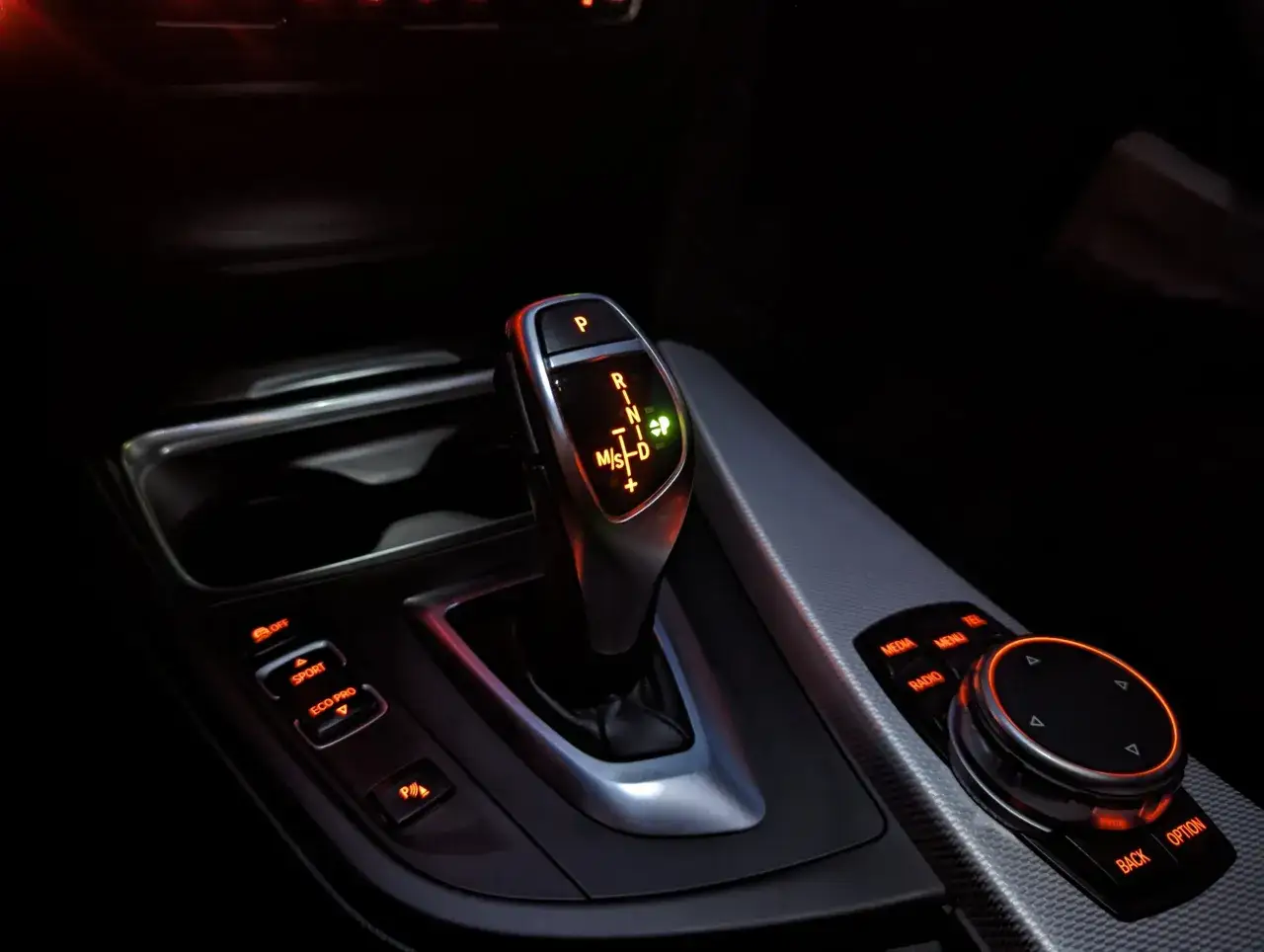 Bieg ZF 8HP w BMW. Widok na dźwignię zmiany bieg&oacute;w, przyciski tryb&oacute;w jazdy (Sport, Eco Pro) i pokrętło iDrive.