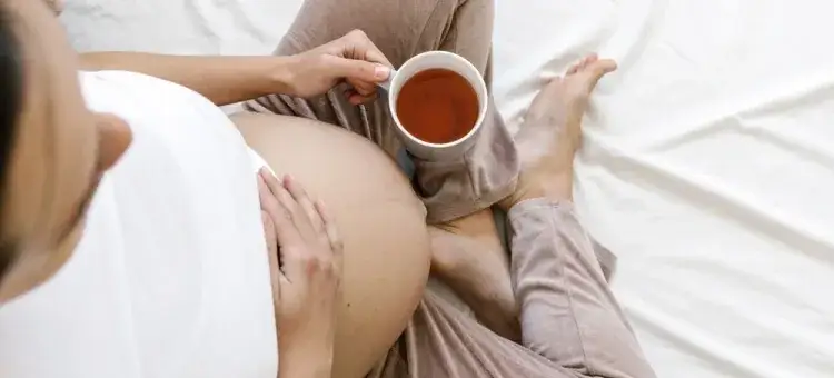 Kobieta w ciąży pijąca herbatę ziołową
