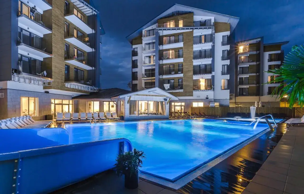 Nowoczesny hotel z basenem w Szklarskiej Porębie, oświetlony nocą, zaprasza do relaksu.