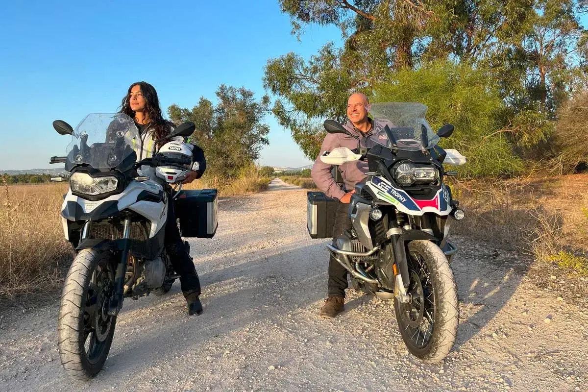 Para na motocyklach 500 cm3, gotowa na przygodę na piaszczystej drodze wśr&oacute;d drzew.