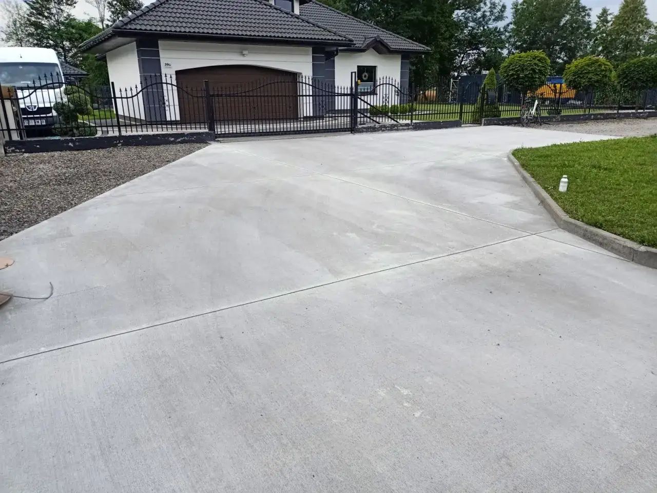 Nowy, betonowy podjazd przed domem. Idealny materiał, z czego zrobić podjazd, który zapewni trwałość i estetykę.