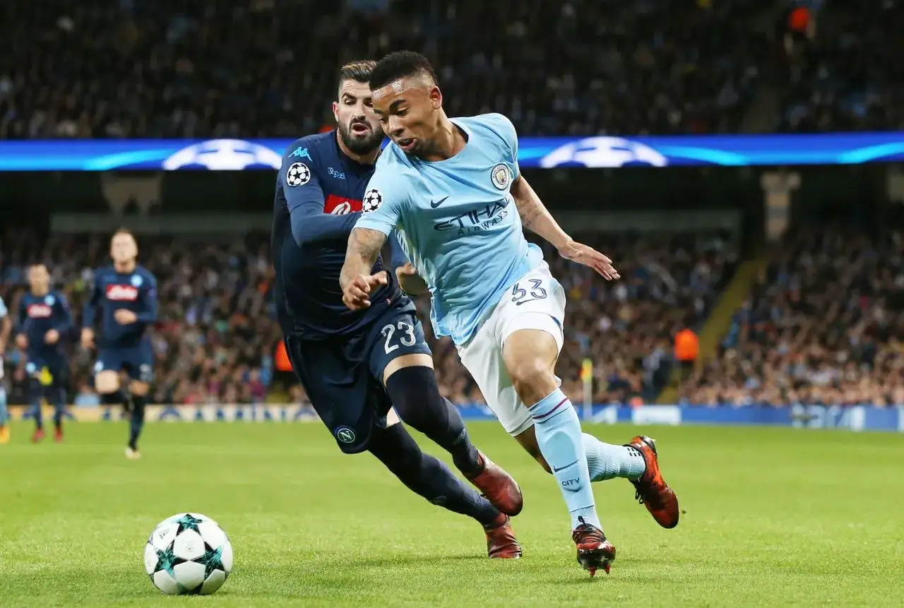 Piłkarze Manchesteru City i Napoli walczą o piłkę na murawie. To właśnie na takich emocjonujących meczach leci Liga Mistrzów.